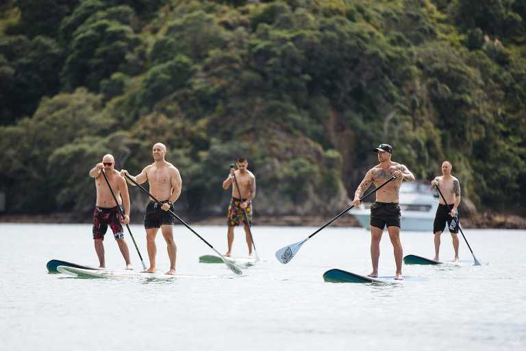 group of men standup paddle boarding