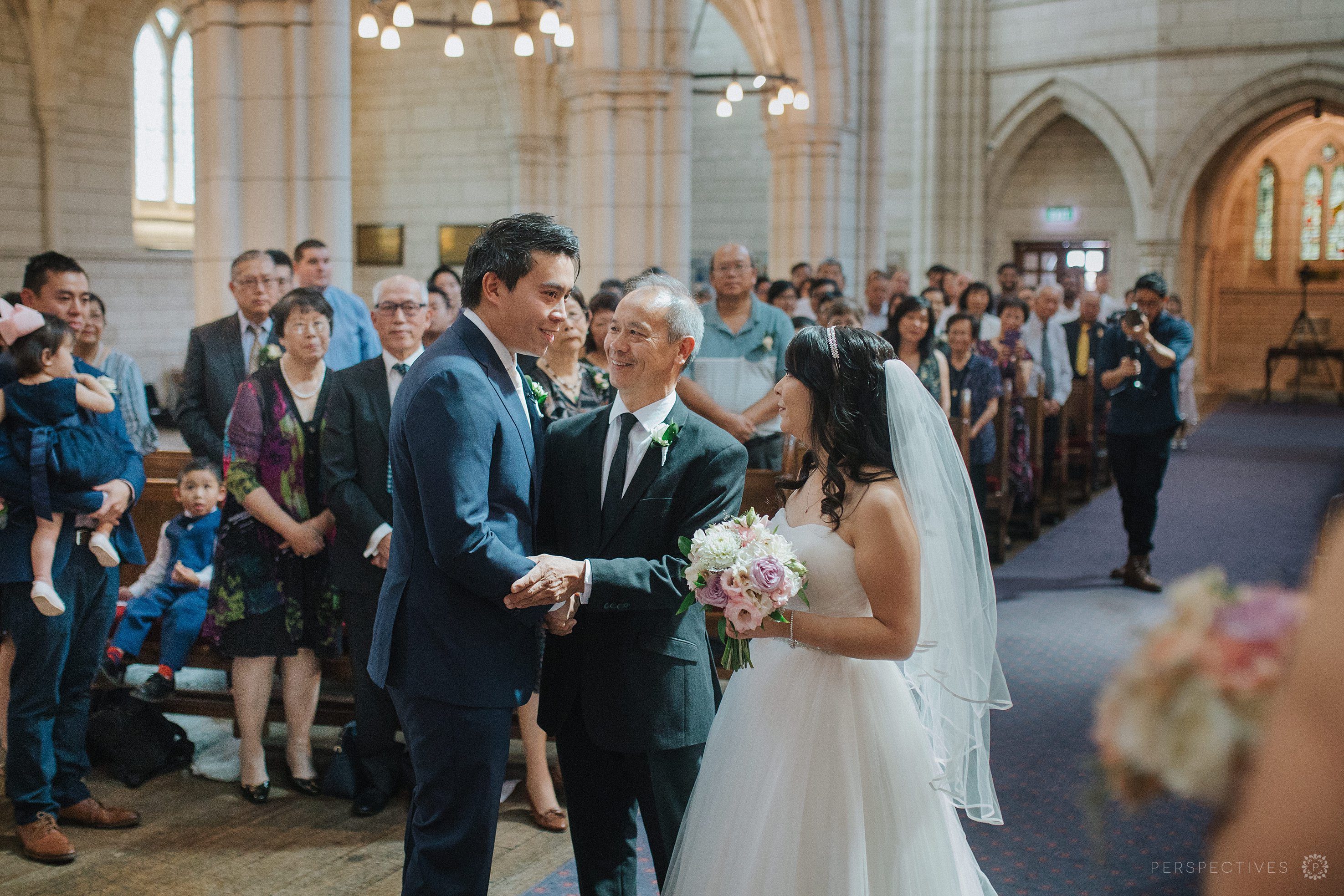 father gives bride away to groom in wedding ceremony