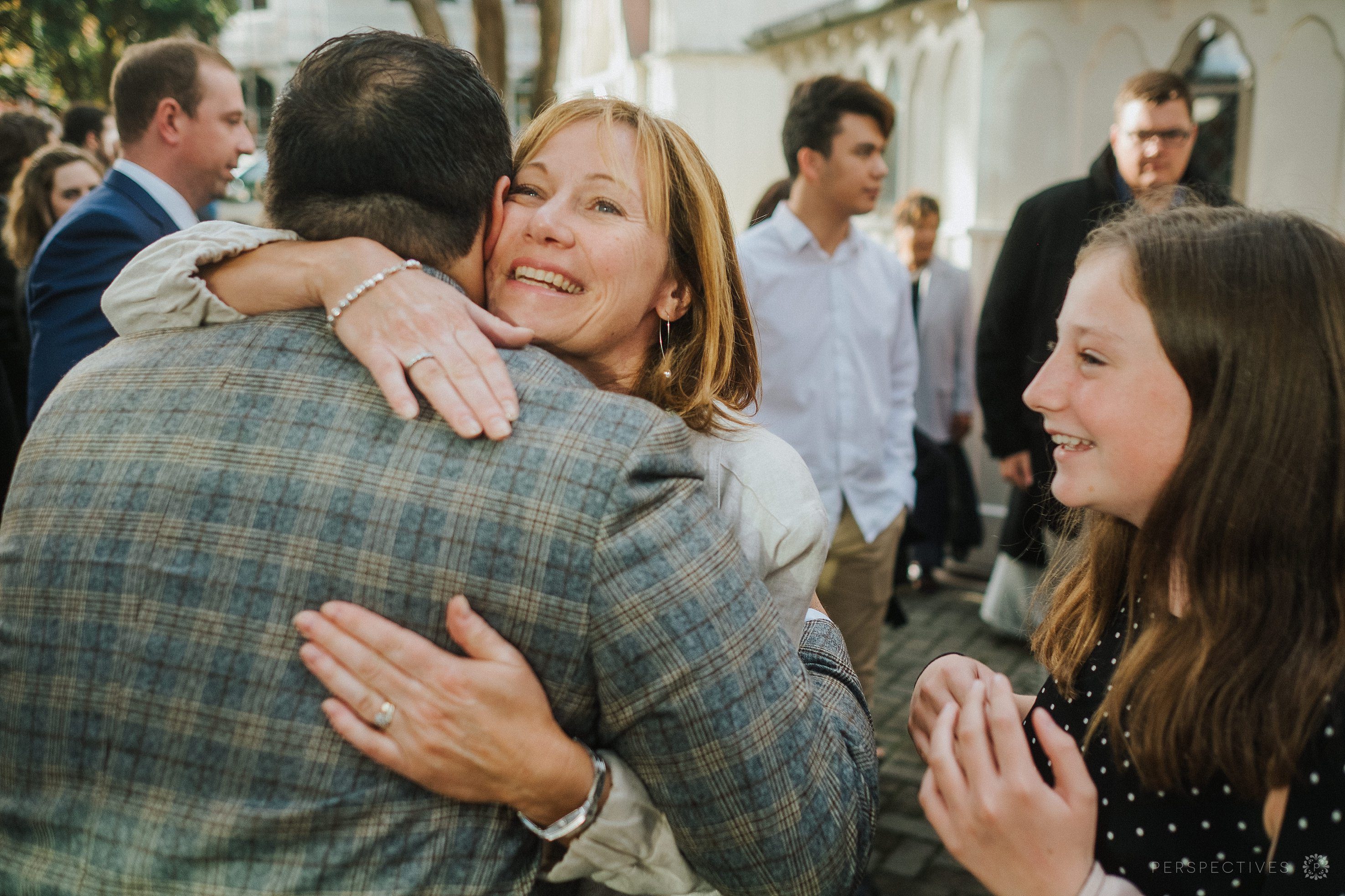 guest hugs groom after wedding