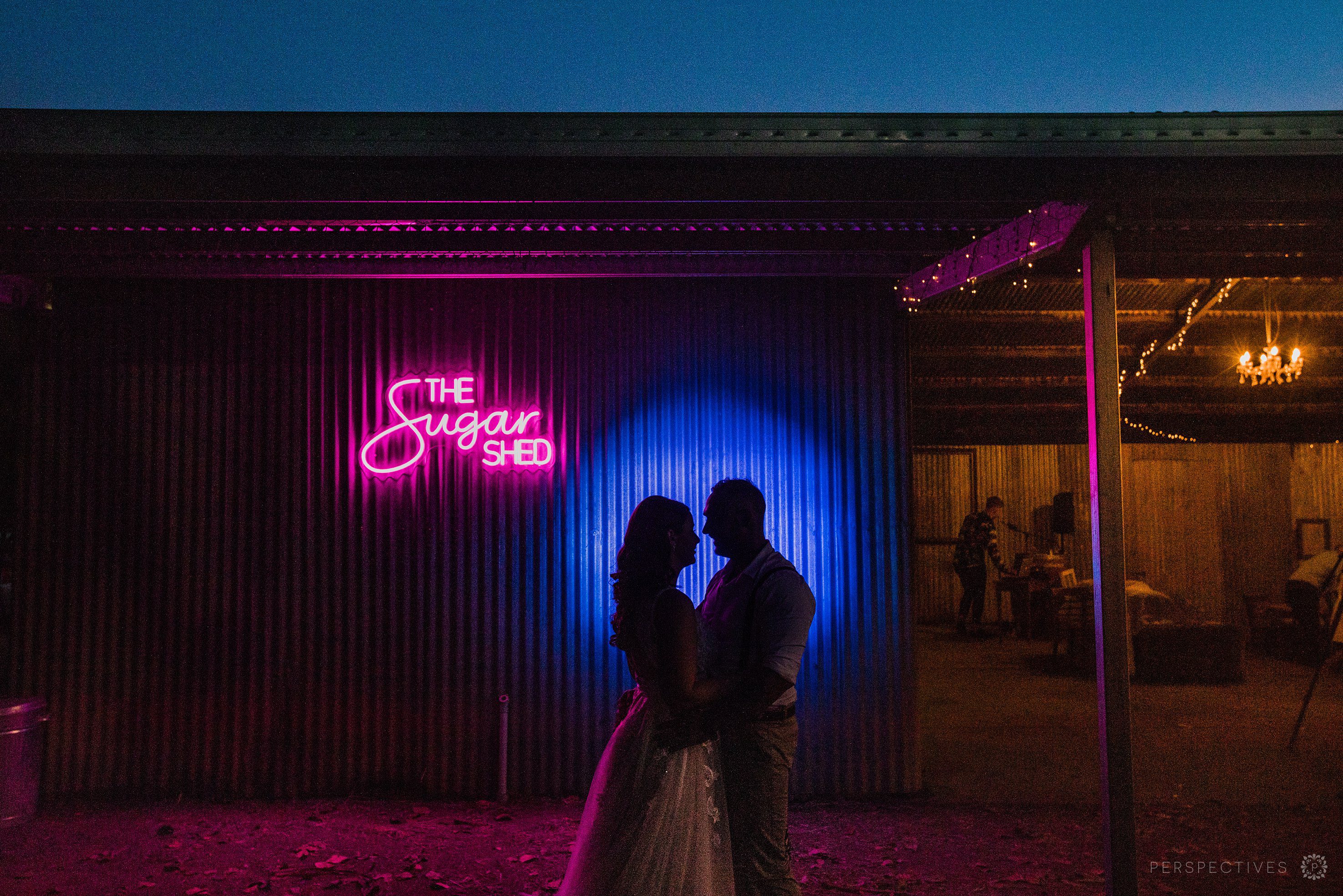 backlit photo with bride and groom at night at Laloli Gardens, Cairns wedding venue