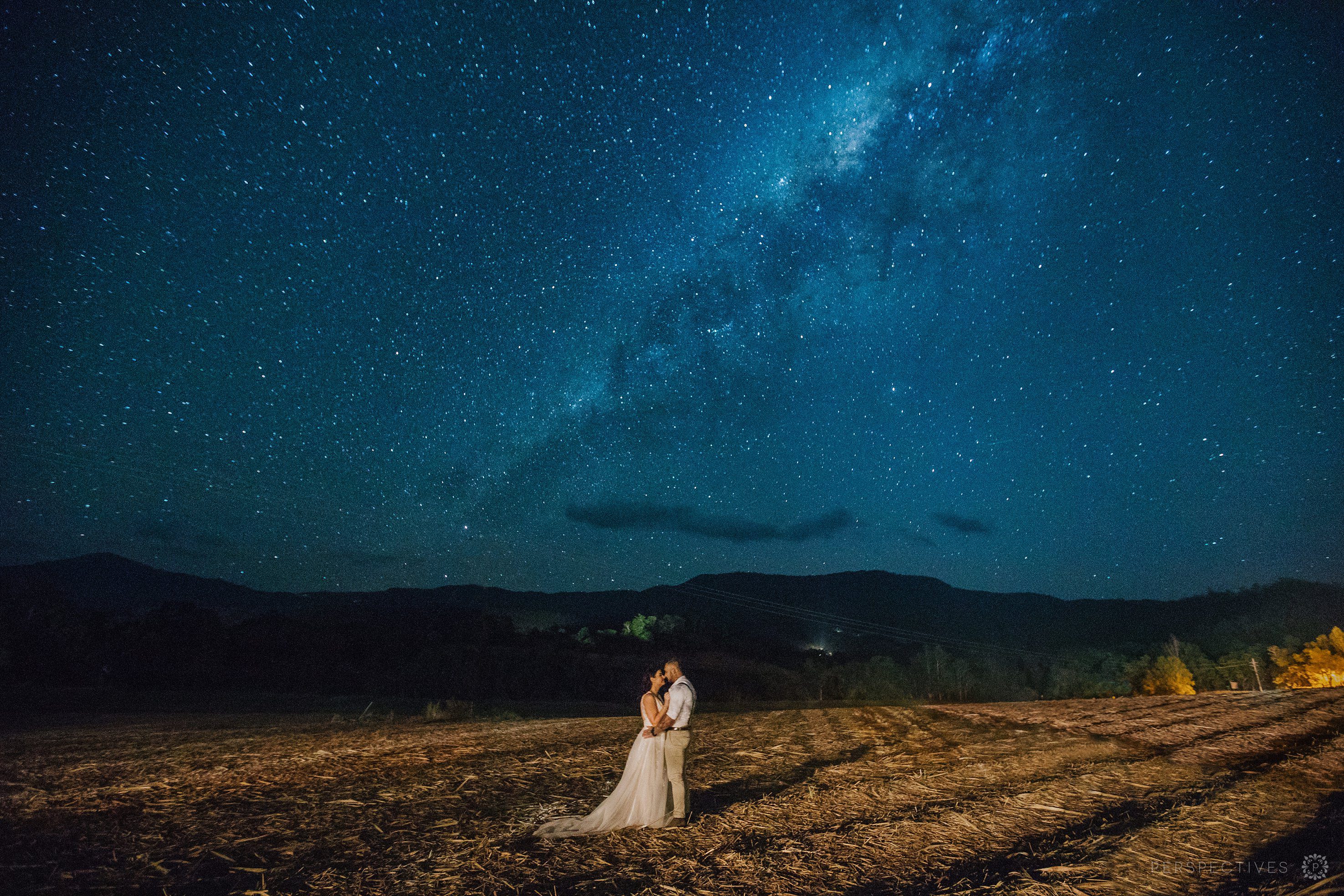 Bride and groom stand under the stars at Laloli Gardens wedding venue in Cairns, Queensland