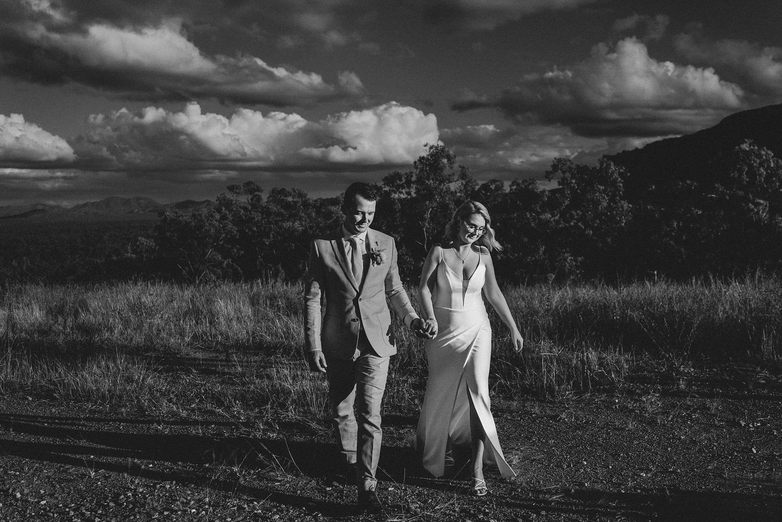 Black and white image of bride & groom walking
