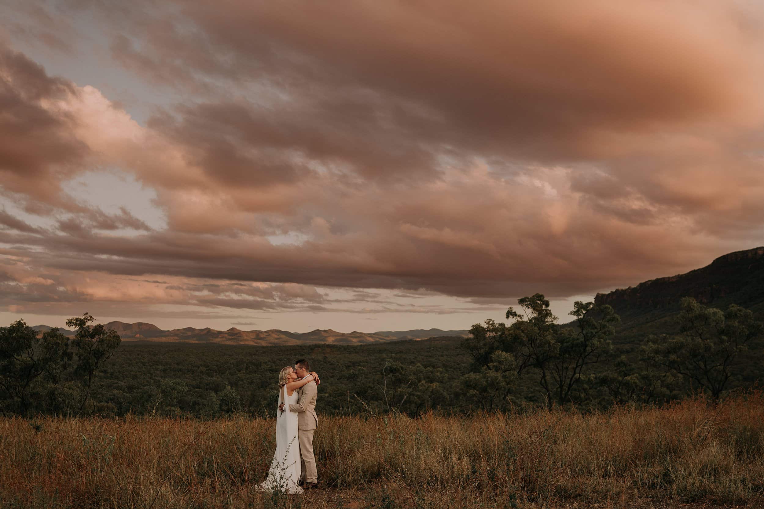 Sunset skies at Mount Mulligan lodge with wedding couple kissing in the distance