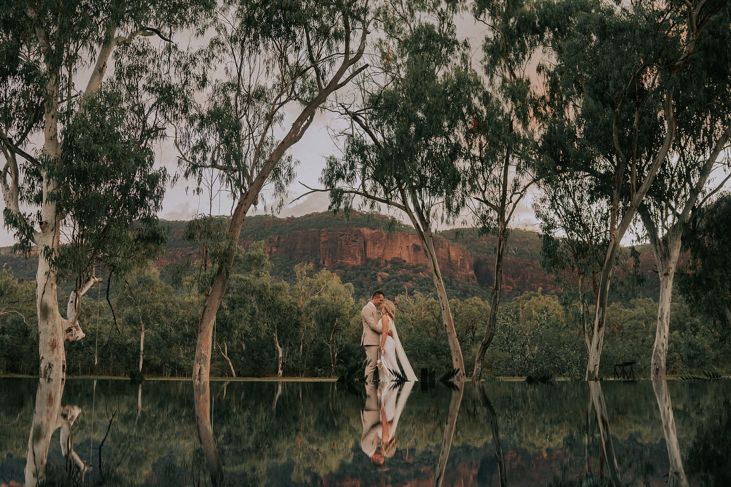 Reflection of bride and groom in pool at Mount Mulligan Lodge