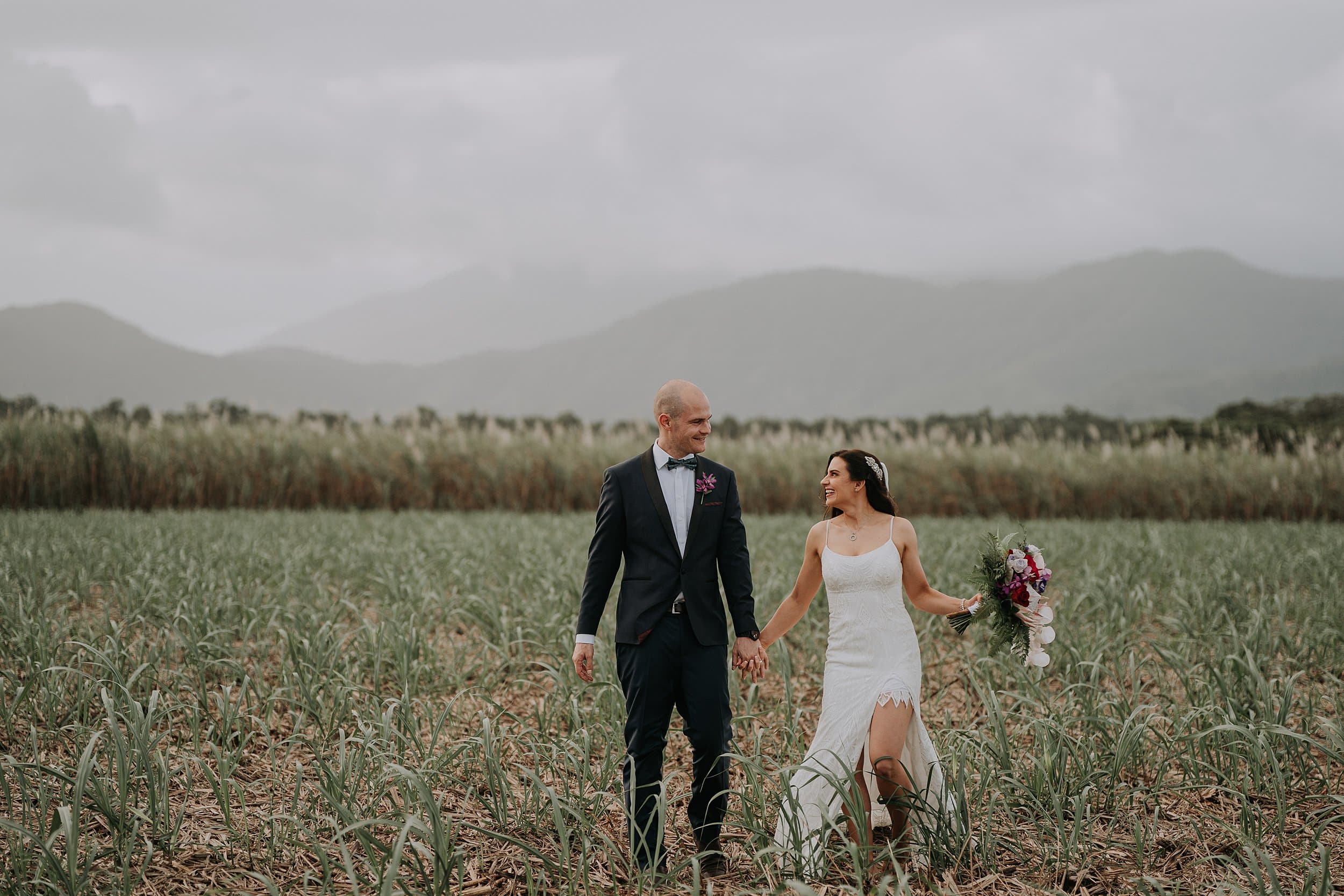 Bride and groom walking through sugar cane wedding photo