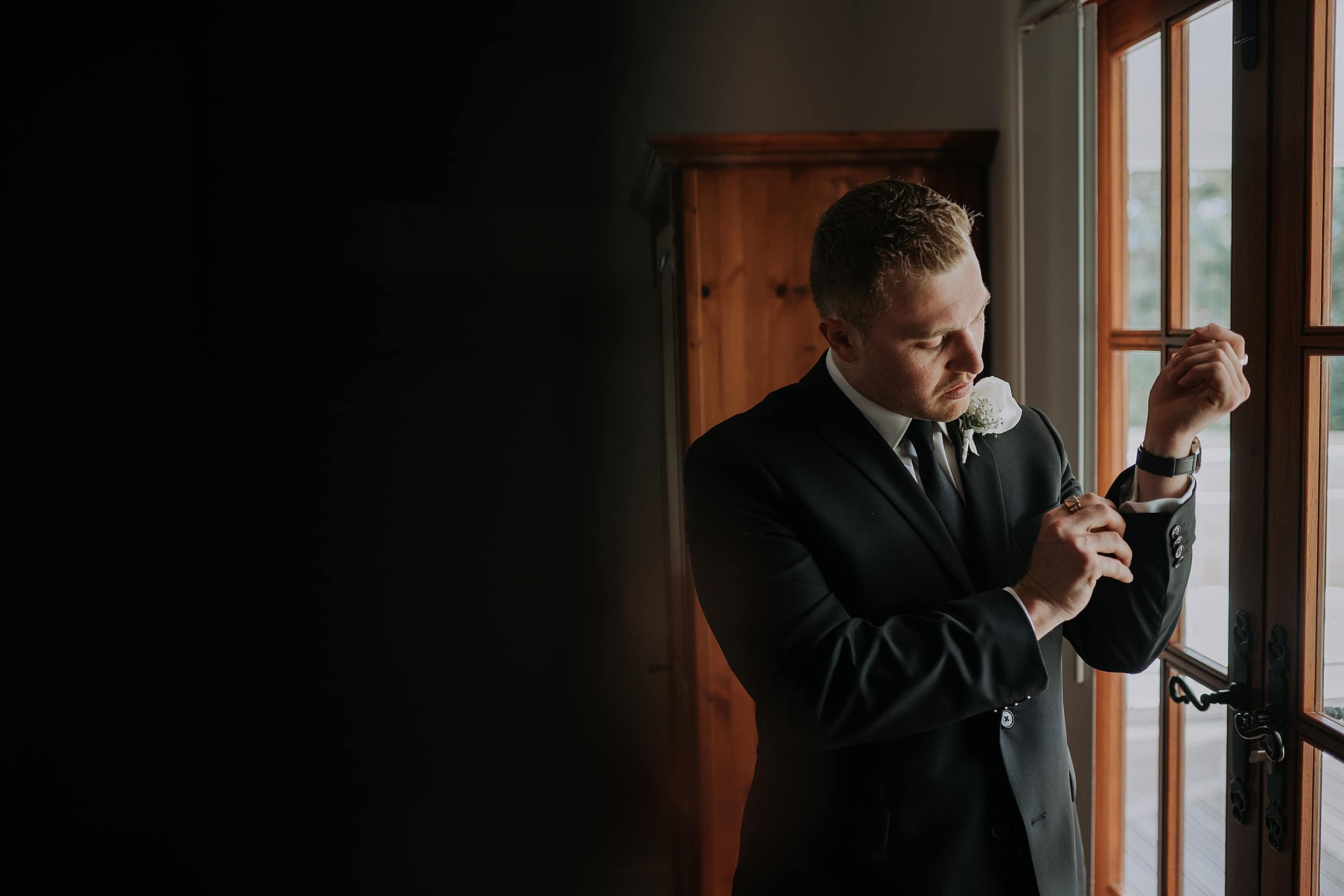 Groom adjusts suit sleeve at Lakeside Retreat wedding Port Douglas