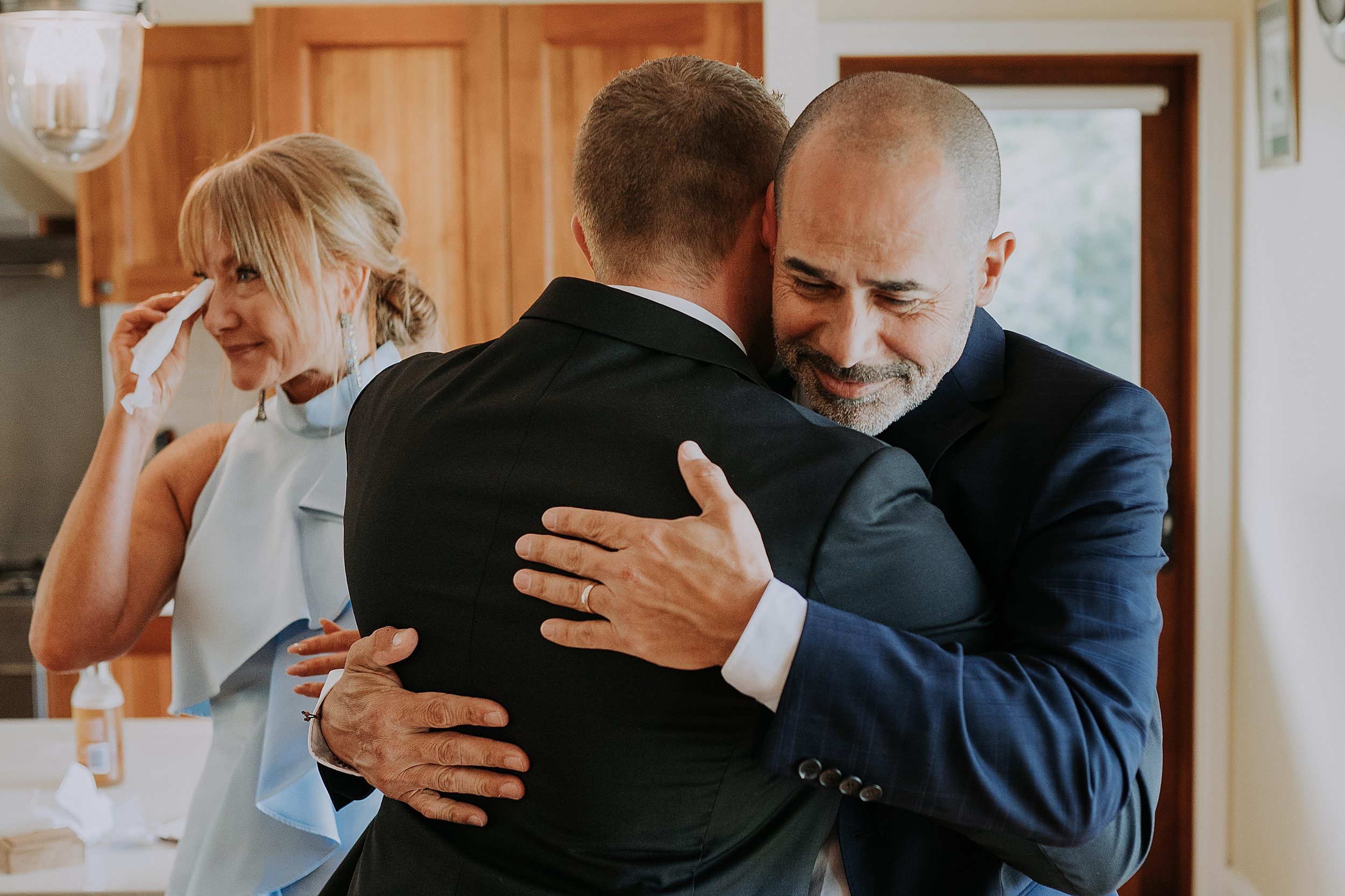 Groom's parents hug him